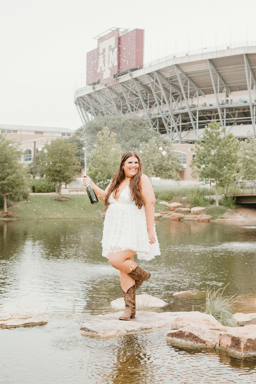 A Texas A&M senior and grad doing a champagne pop at Aggie Park for senior photos