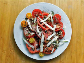 Ein bunter Tomatensalat mit Kürbiskernen.