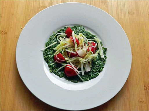 Radieschenviertel und Kohlrabistreifen liegen auf einem Salatteller.