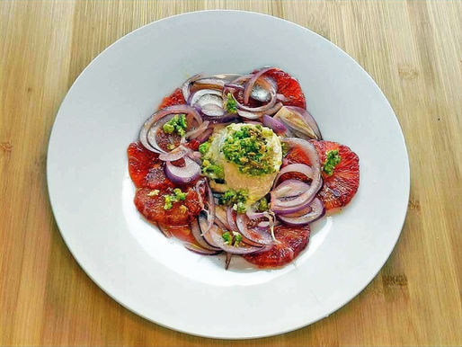 I Scheiben geschnittene Blutorangen werden von einem heißen Ziegenkäse namens Crottin gekrönt.