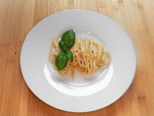 Eine Portion Linguine mit Zitronencreme und Basilikum als Dekoration.