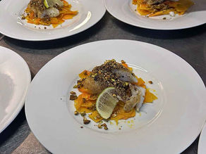 Ein Stück gebratener Fisch auf goldgelbem Butternut-Kürbis.