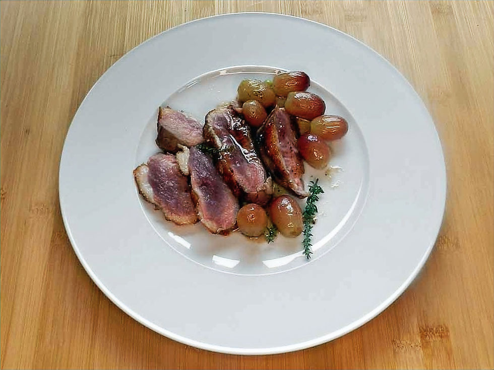 Entenbrust mit gebratenen Trauben. Wer es weniger rot mag, brät das Stück Fleisch mehr durch. Foto: kochgesellschaft