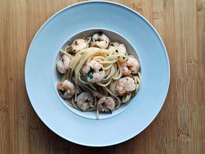 Ein tiefer Teller, gefüllt mit Spaghetti und Garnelen.