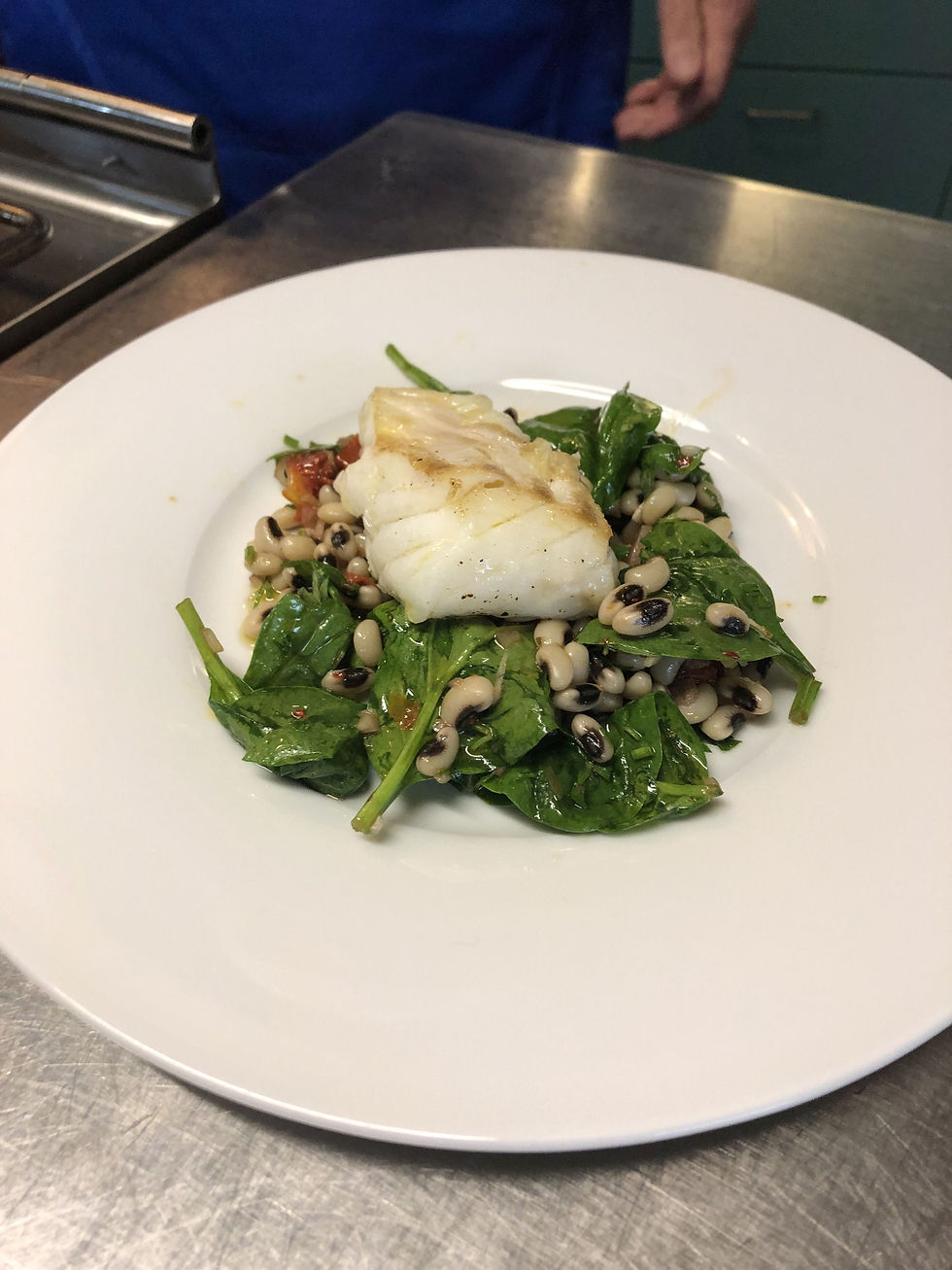 Kabeljau auf einem Salat aus Augenbohnen und Babyspinat. Foto: kochgesellschaft