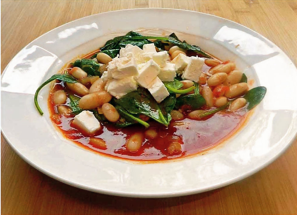 Wärmt: Suppe aus weißen Bohnen, Tomaten und Spinat, die mit Feta getoppt wird. Foto: kochgesellschaft