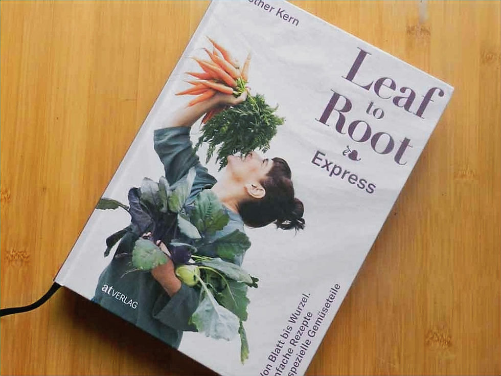 Ein Buch, auf dem eine Frau abgebildet ist, die viel Gemüse im Arm hält.