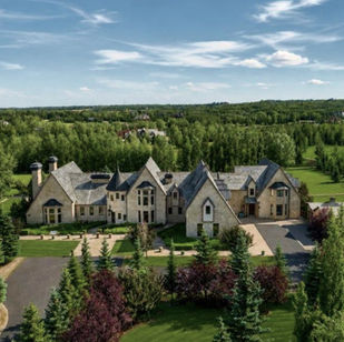 A French style stone chateau on 8.8 acres of wooded manicured lawns, a turret and steep gabled roofs.