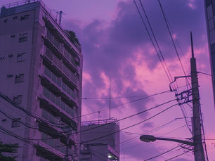 City skyline at dusk with purple-pink sky, buildings, power lines, and a full moon. The mood is serene and atmospheric.