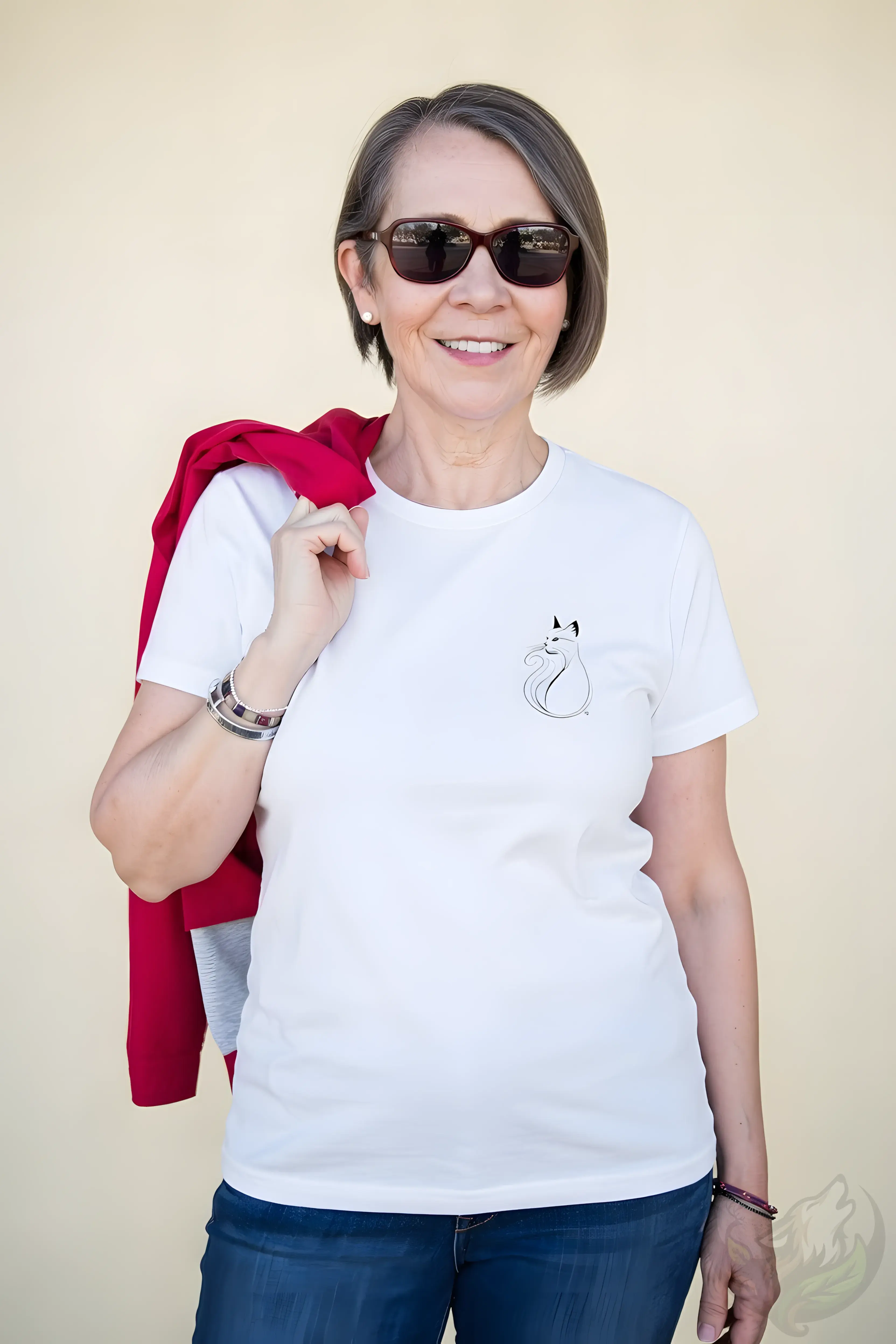 Smiling woman with gray hair wearing a white fitted t-shirt with a delicate minimalist cat line art on the left chest.