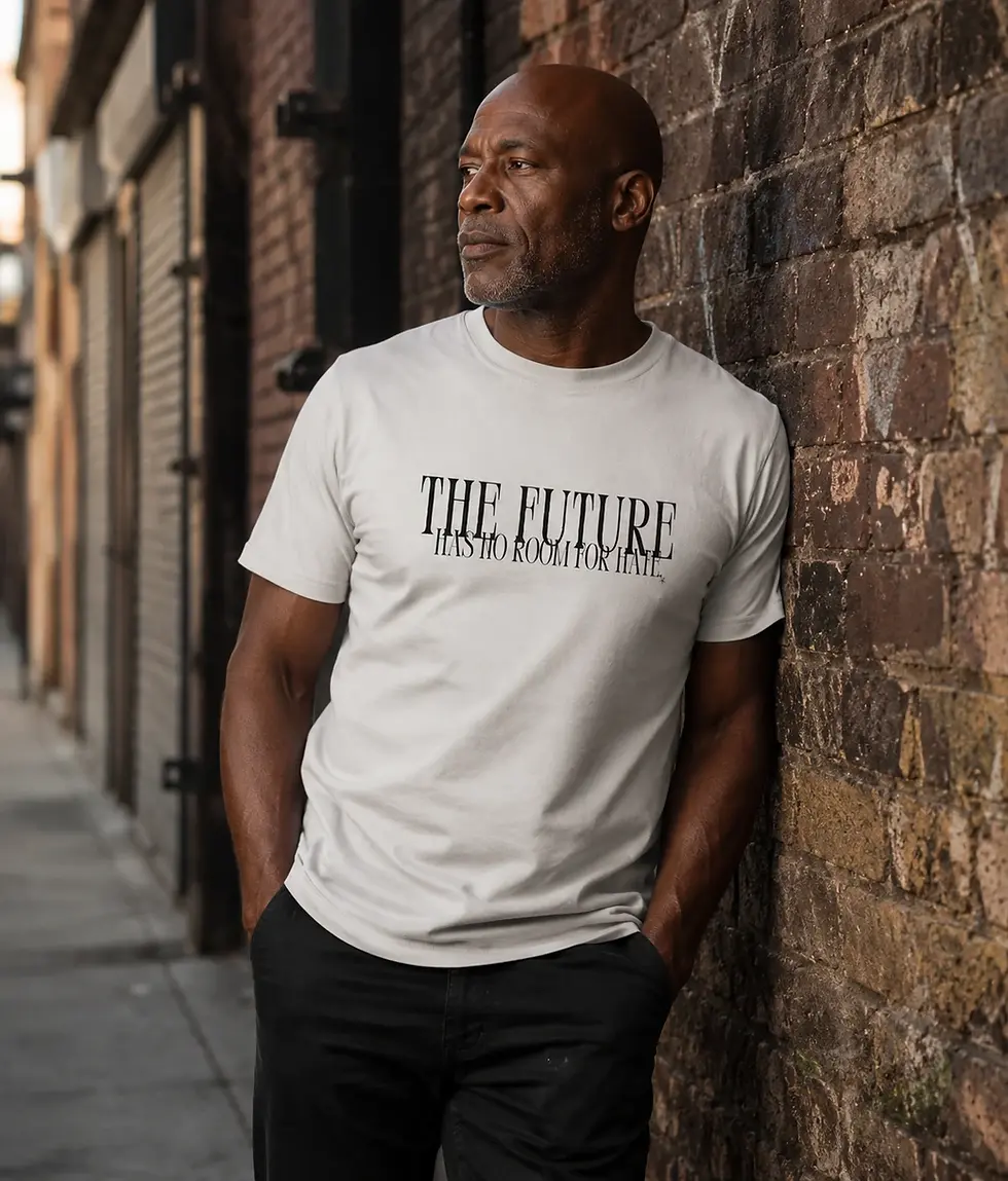 Black male wearing white unisex The Future Has No Room For Hate shirt in urban brick wall lifestyle scene
