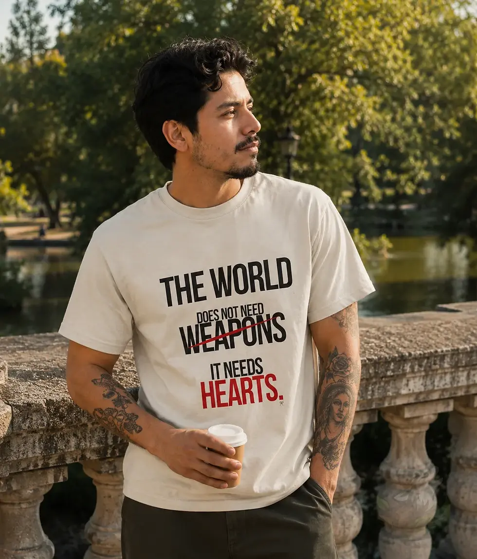 Man wearing natural unisex The World Needs Hearts humanity shirt outdoors by water in peaceful setting