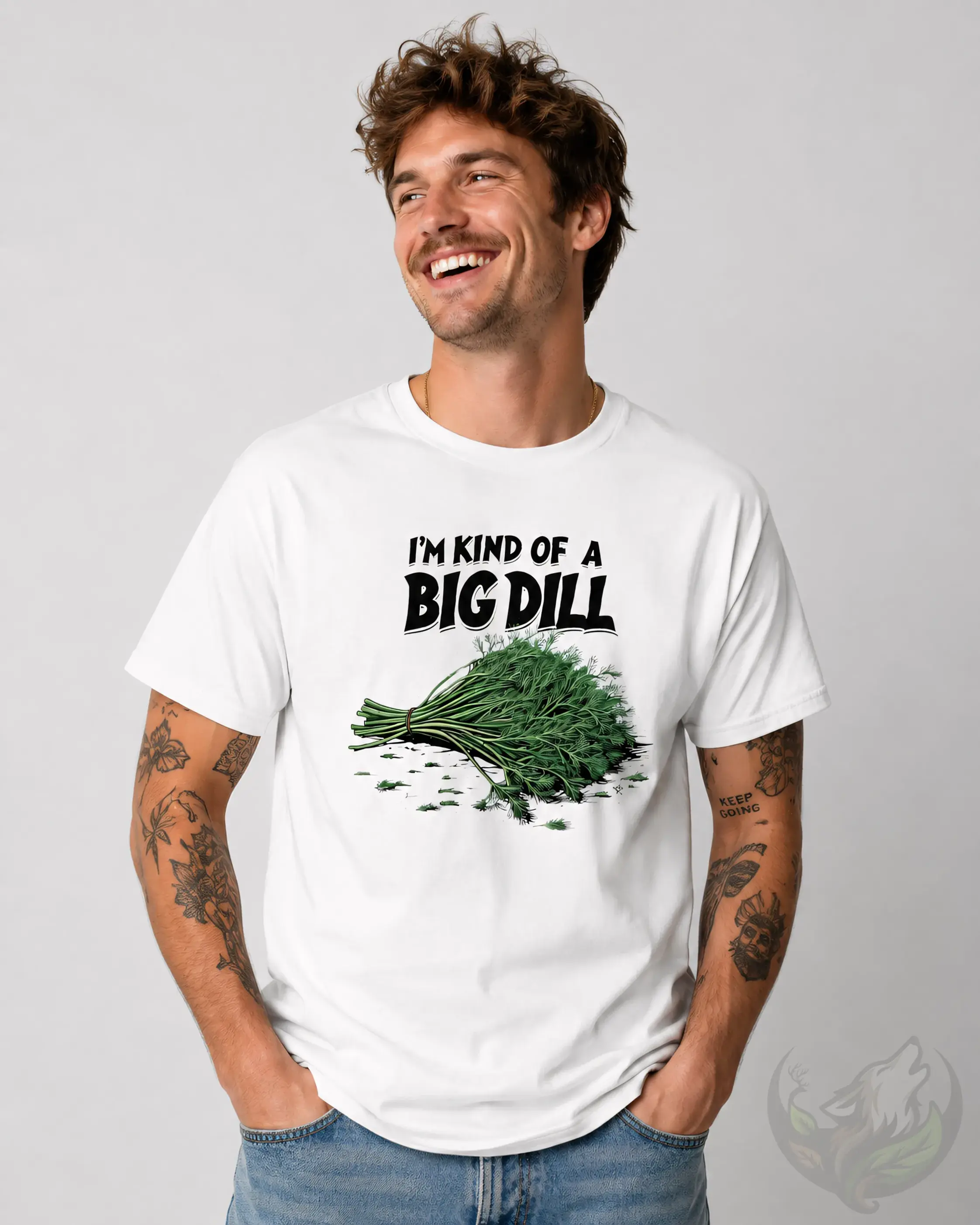 Smiling tattooed man wearing white Kind Of A Big Dill funny food pun t-shirt against studio background