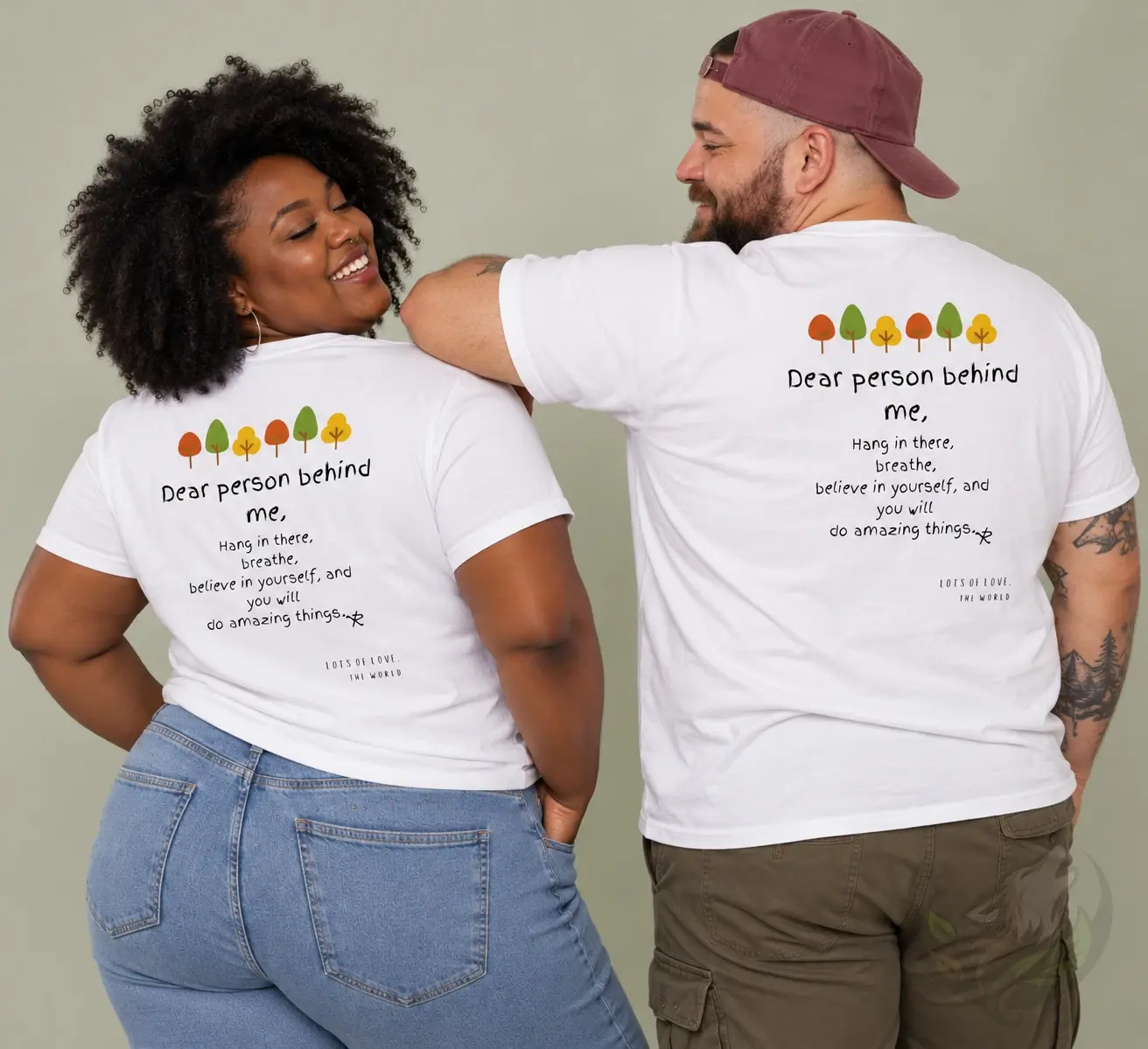 Two people showing the back print of white Dear Person Behind Me shirts