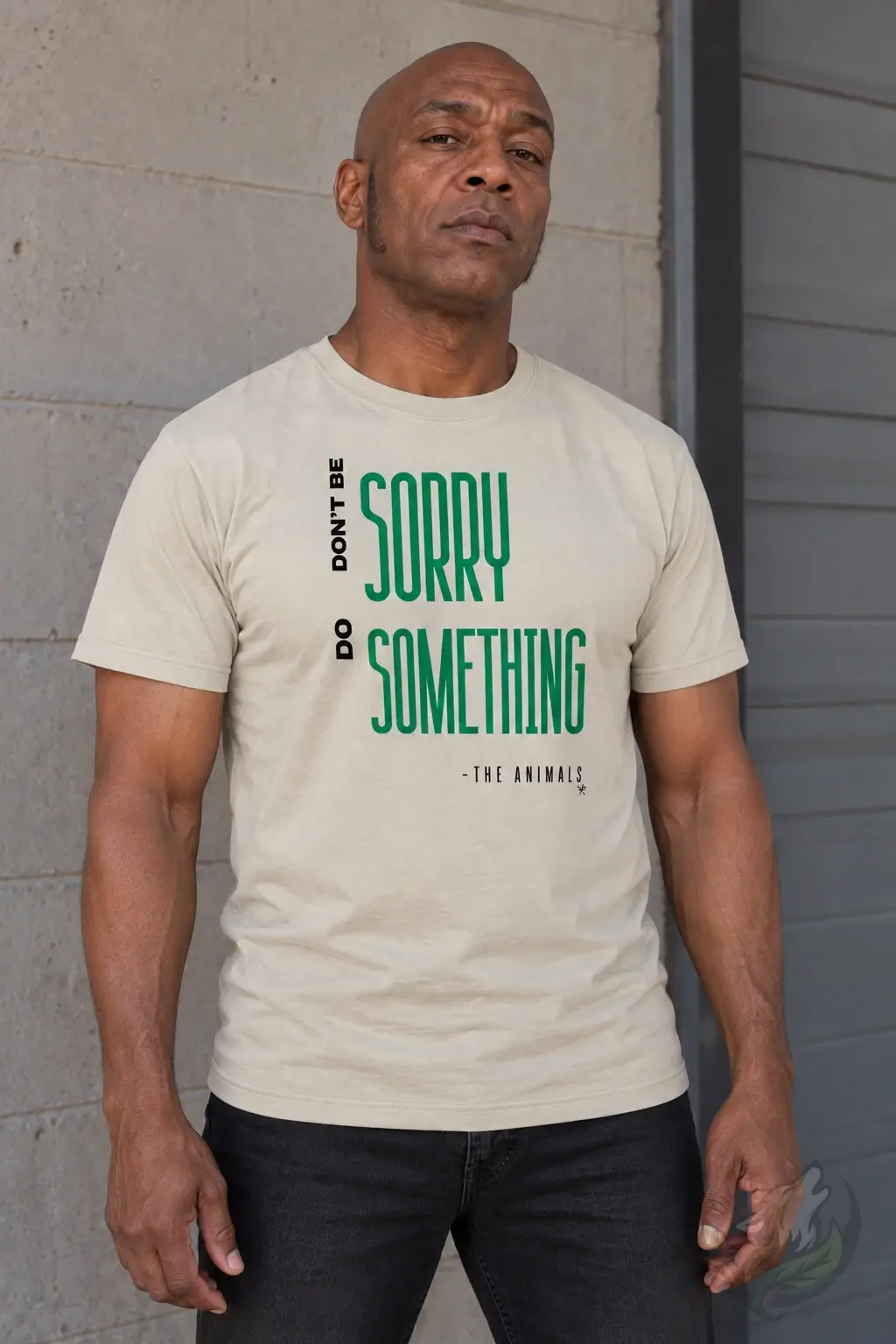 Bald man wearing beige men's crew neck T-shirt with green Don't Be Sorry Do Something animal rights slogan outdoors.