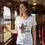 Thumbnail: Woman wearing a white scoop neck tee with a cartoony Chewbacca‑style vegan design while standing in a vintage train carriage.