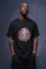 Bald male model wearing black unisex Griffin shirt with fantasy creature print in studio setting