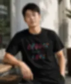 Man wearing black unisex Choose Love shirt sitting outside cafe in relaxed everyday lifestyle moment