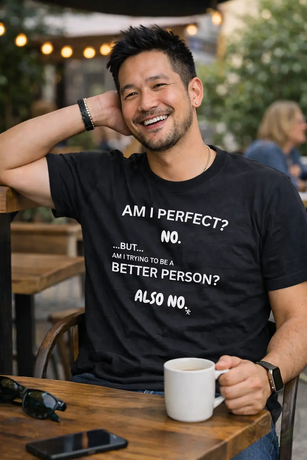 Man wearing black unisex “Am I Perfect? Also No” humor shirt in relaxed outdoor lifestyle scene