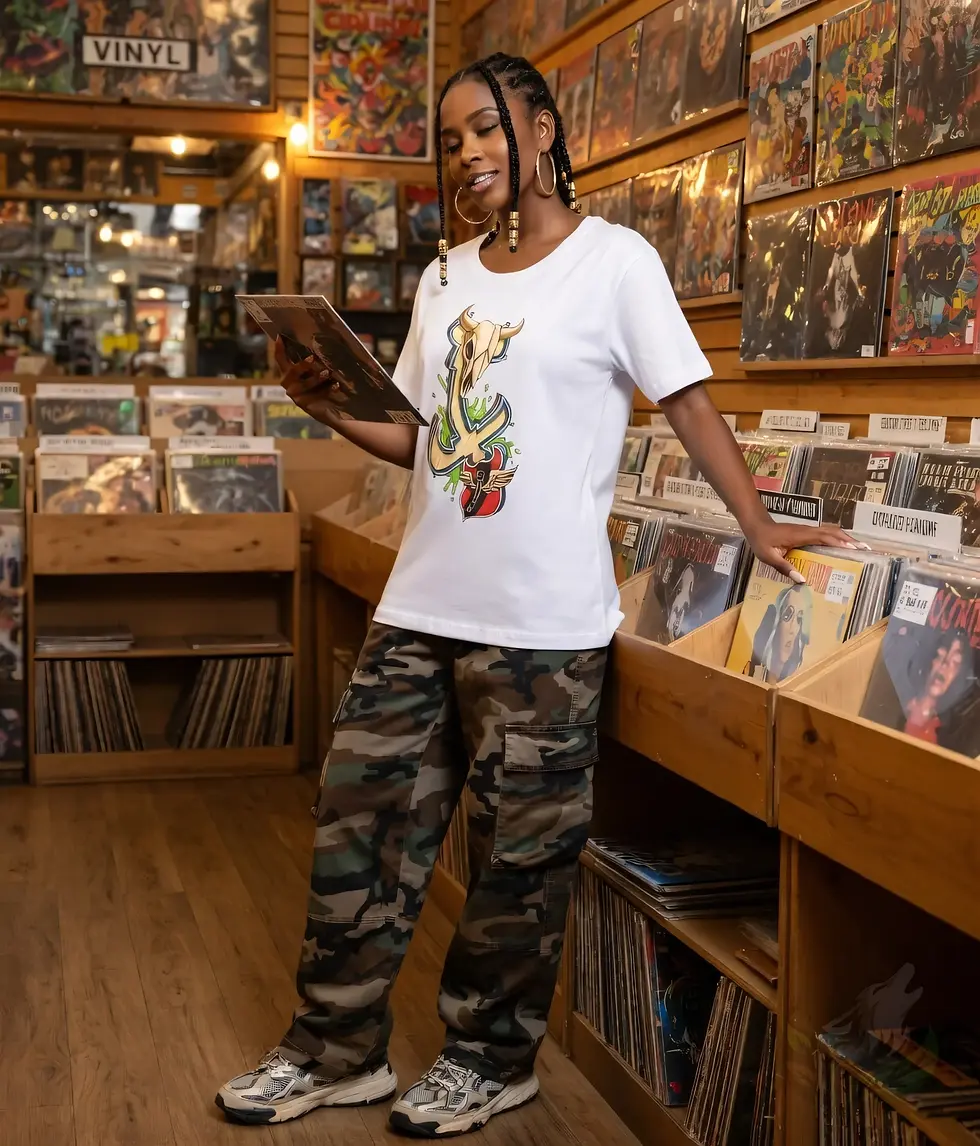 Thumbnail: Woman in a record store wearing a white fitted tee with Def P’s Twisted Cross skull and abstract motif artwork