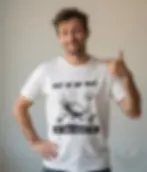 Smirking man wearing white unisex t shirt with Out Of My Way My Bed Needs Me ostrich design clean studio portrait realistic a