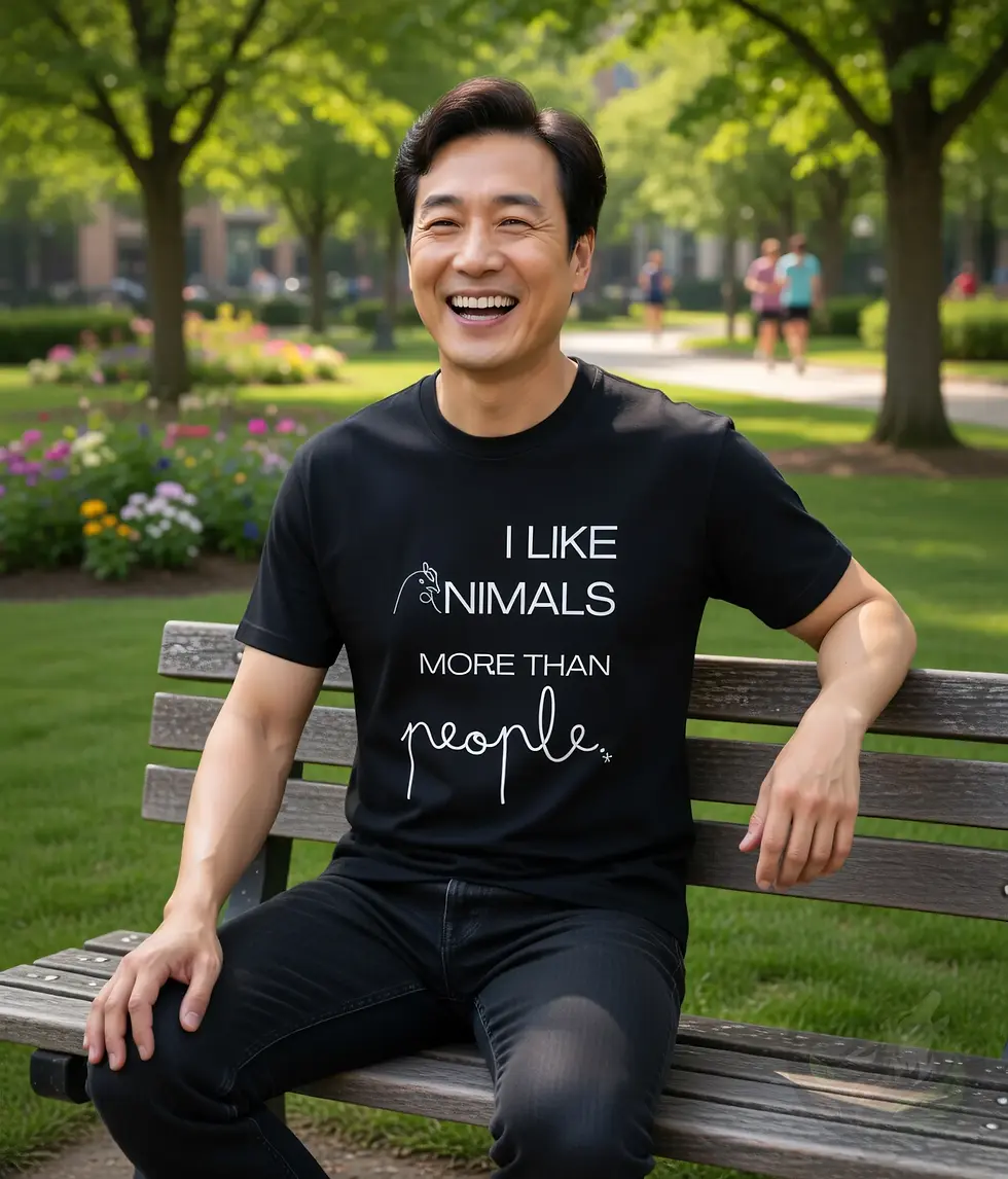 Miniaturbild: Black unisex t-shirt on laughing man sitting on park bench, "I Like Animals More Than People" fun vegan quote design.White un