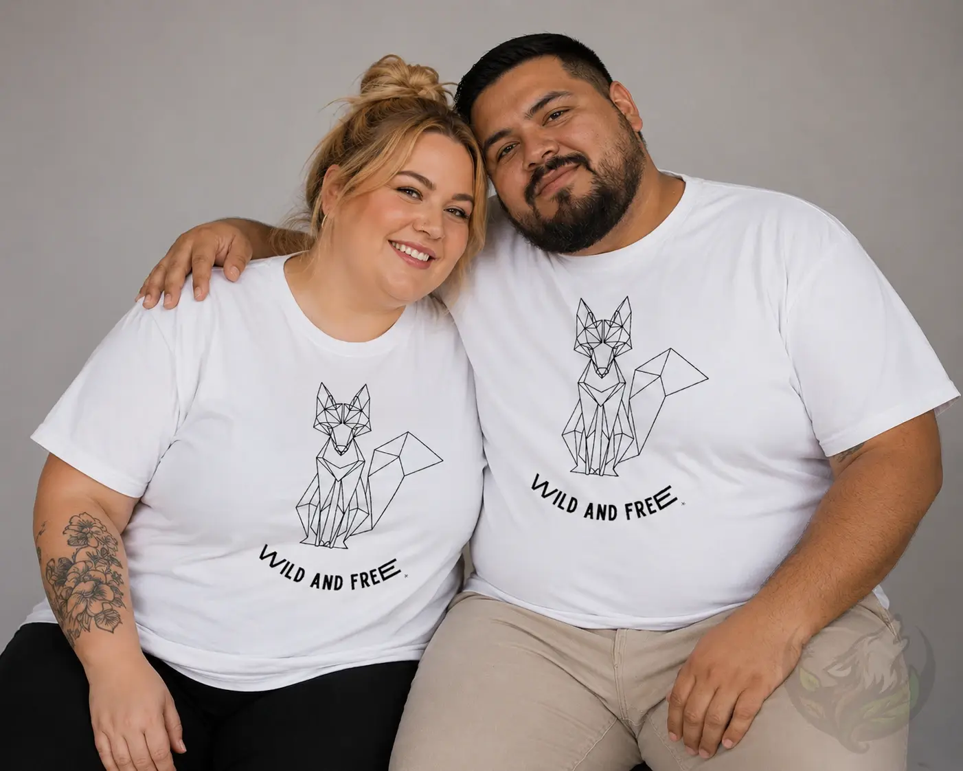 Couple wearing white shirts with matching geometric sitting fox Wild and Free designs