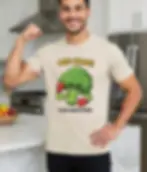 Natural unisex t-shirt worn by smiling bearded man in kitchen, "Cauli Smash! Plant-Based Power" cauliflower boxer graphic.