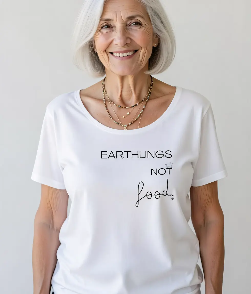 Thumbnail: White wide‑neck shirt featuring the message “Earthlings not food” with a small cow icon, worn by an older woman smiling.
