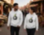 White unisex hoodies with angry graffiti pear design worn by couple walking through a market.