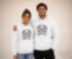 Couple wearing matching white Good Life Dog hoodies with cute cartoon puppy design in a studio portrait