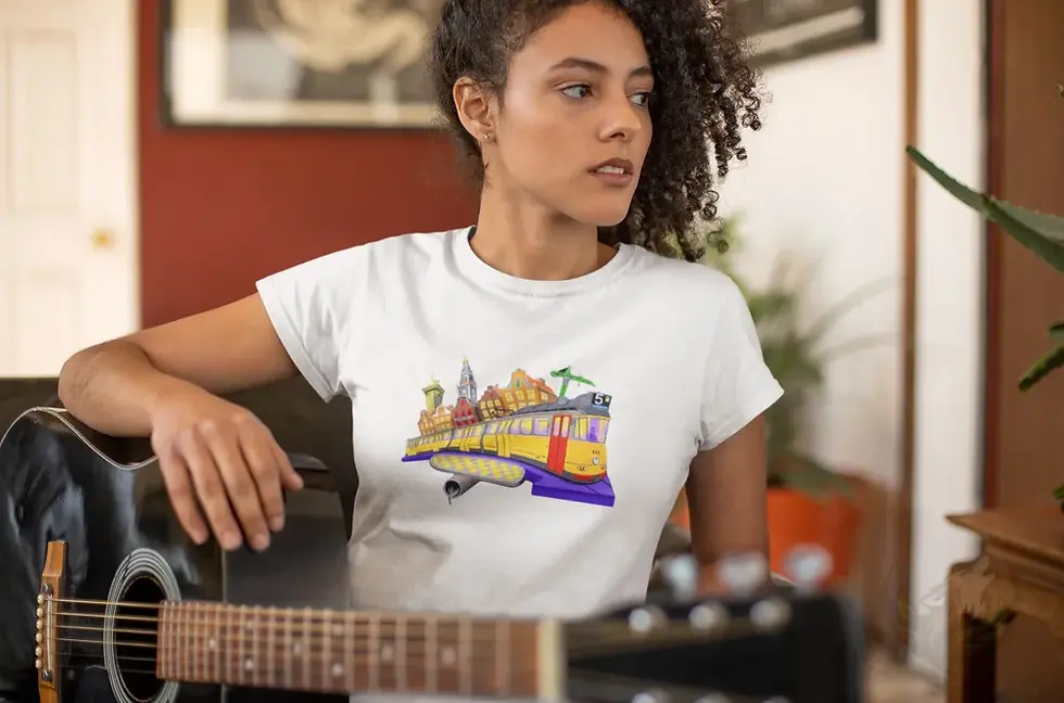 Thumbnail: Person sitting indoors with a guitar wearing a white fitted tee featuring Def P’s Tram 5 artwork of a tram and cityscape