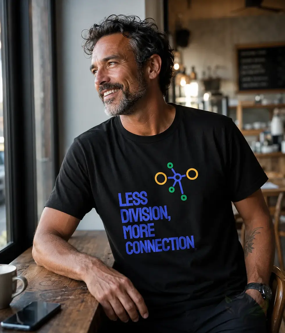 Man wearing black unisex Less Division More Connection humanity shirt in relaxed cafe lifestyle scene