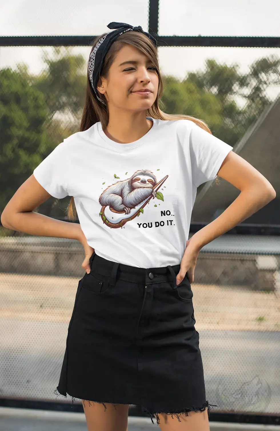 Smiling woman with bandana standing outdoors wearing a white fitted t-shirt with "No.. You Do It." lazy sloth graphic.