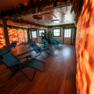 Himalayan salt wall with zero gravity chairs arranged for a meditation or sound healing class in tranquil event space.