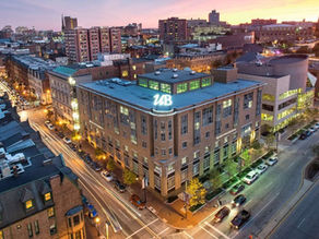 corner city building at night with UB in lights on the top