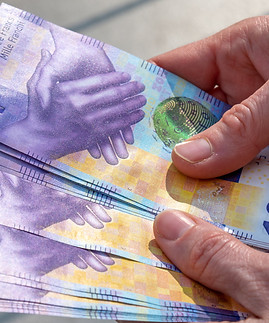 hands holding a stack of swiss francs money.jpg