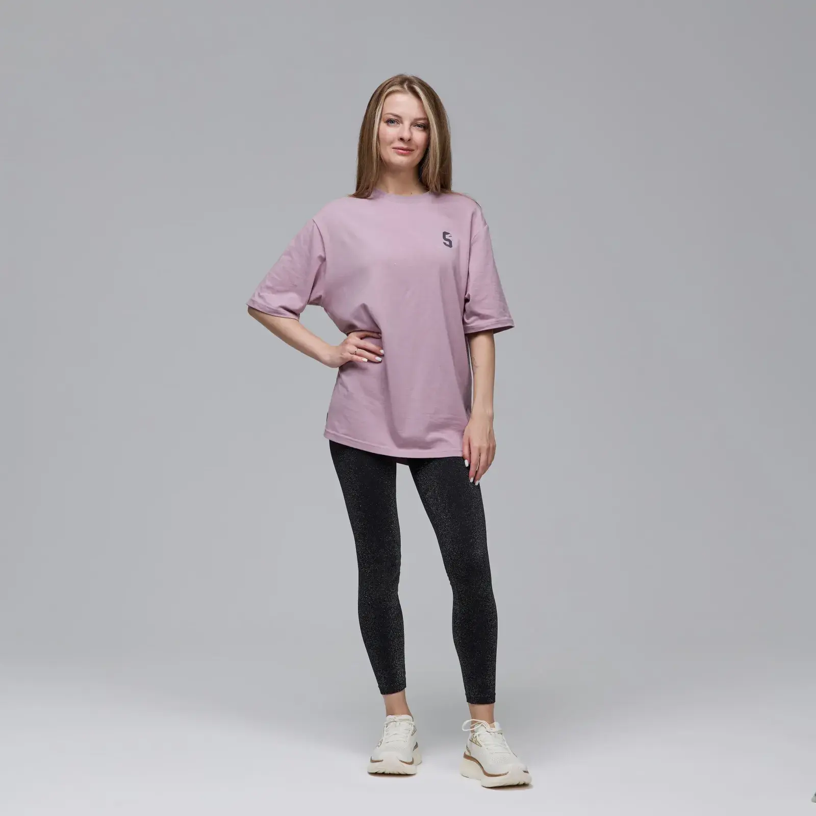 Жінка в рожевій футболці, чорних штанах. Футболка Saucony STOPWATCH SHORT SLEEVE р.L. Стильний вигляд.