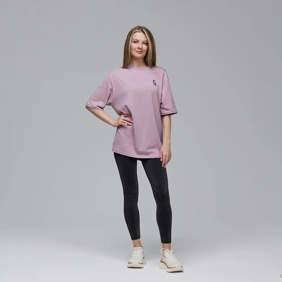 Жінка в рожевій футболці з логотипом, чорних штанях і кросівках. SwimDream