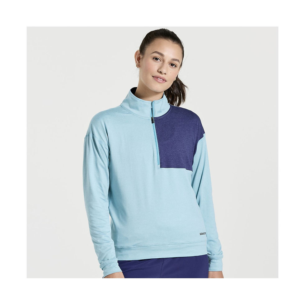 Жінка в блакитному реглані Saucony SUNDAY 1/4 ZIP (розмір L), усміхається. Інтернет-магазин SwimDream