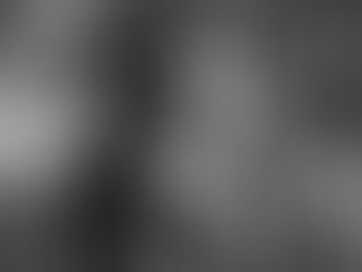 Two people smiling, embracing on a red carpet. Background: Disney's "Queen of Katwe" text on a white backdrop. Formal attire, joyful mood.