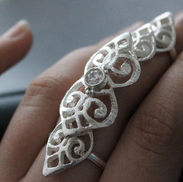 Hopeinen panssarisormus kivellä.