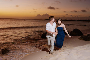 Couple running along the shoreline at sunset on Arashi Beach Aruba, captured by Edrxck, an Aruba photographer specializing in romantic beach photography