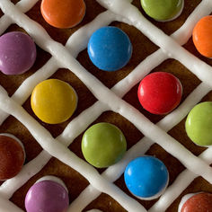 Criss-cross icing with multicolour chocolate buttons in between