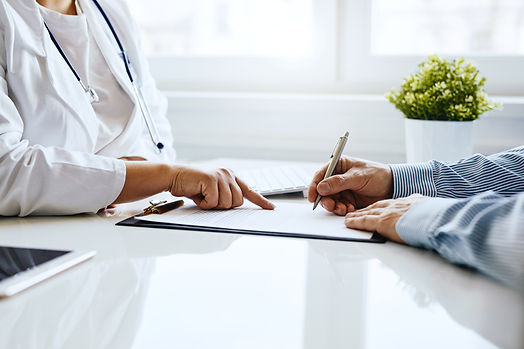 Patient signs a document with his doctor in medical office.jpg