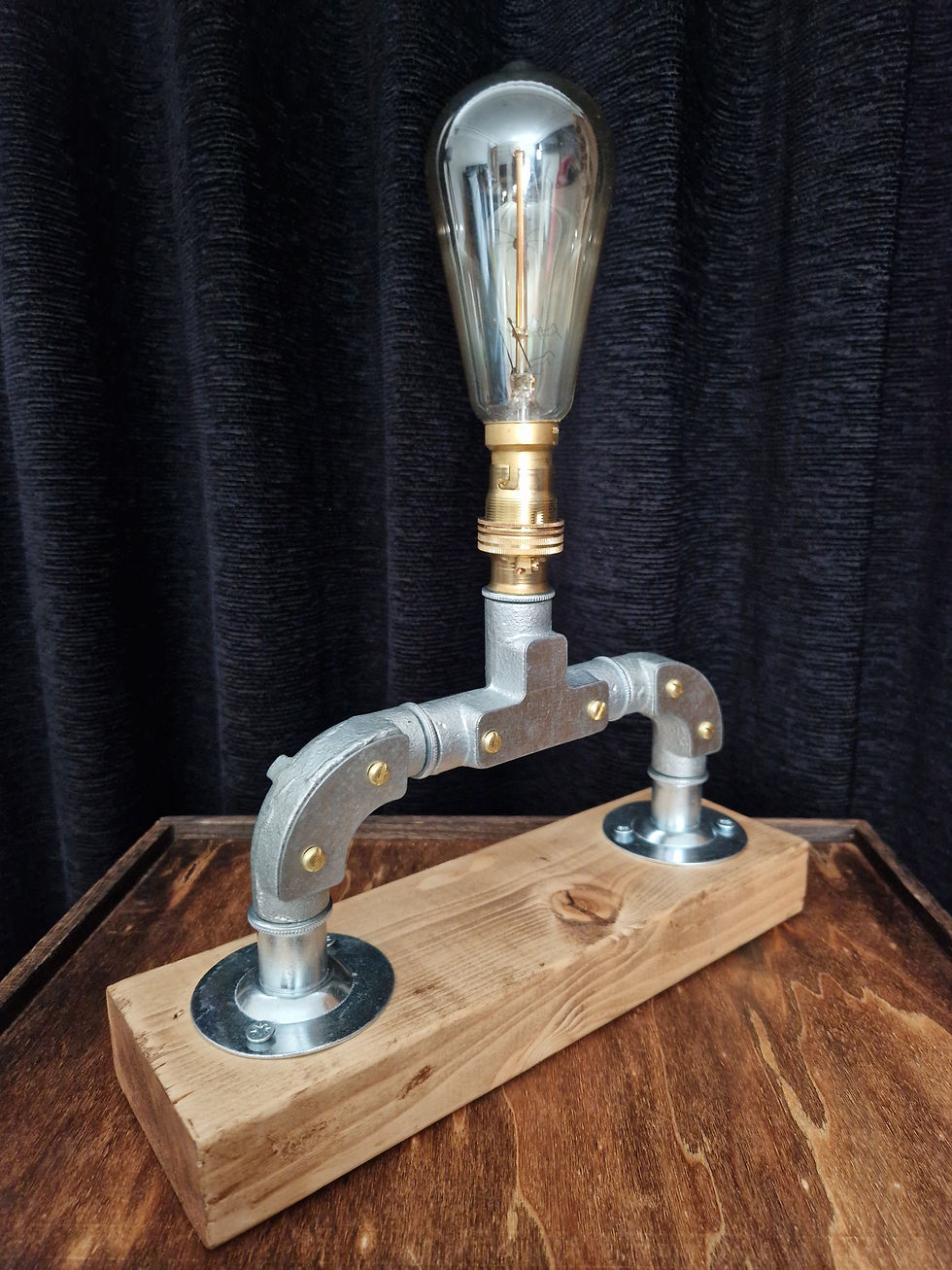 Handcrafted industrial-style table lamp made from galvanized metal pipes and brass fittings, mounted