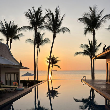 stunning sunset with palm trees and infinity pool a glow with a golden Gulf of Thailand shimmering in the evening sunset