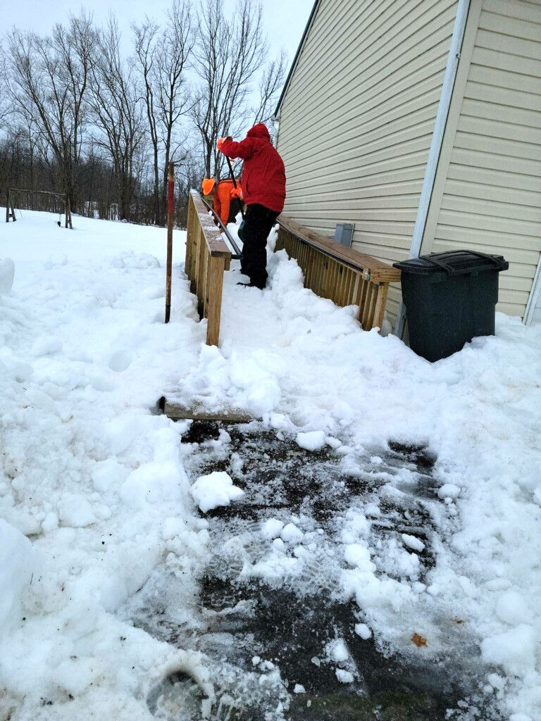 CLEAN-UP CONTINUES – Search and rescue team members work on clearing a wheelchair ramp of snow to provide emergency access. The New York State Federation of Search and Rescue Teams provided volunteers to help Oswego County residents clear snow from the recent lake effect snow storm.