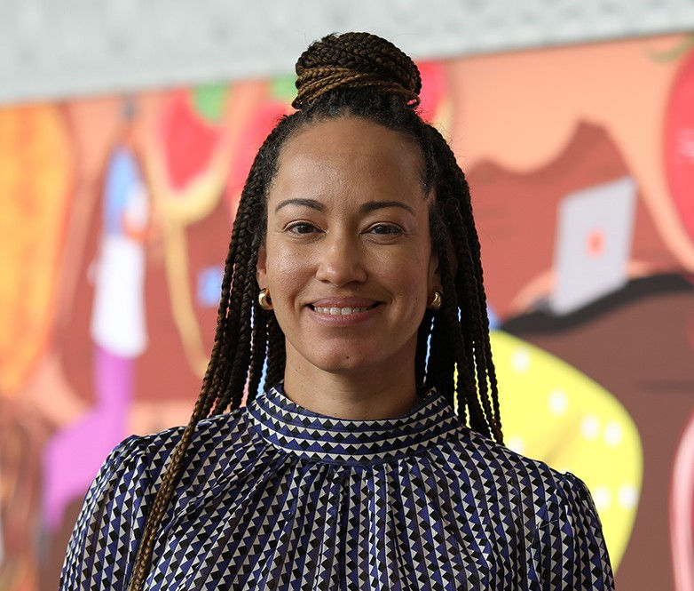 Artist Justine Swindell smiling in a warm indoor portrait.