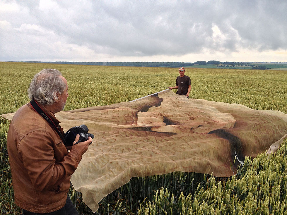 Translucent printed fabric from Paul Emmanuel’s The Lost Men France being handled in a wheat field near Thiepval, France, 2014.
